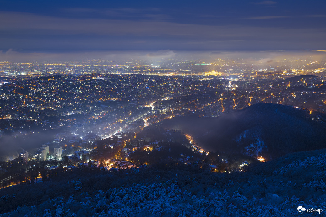 Ködös, párás téli kilátás a fővárosra kék órában, János-hegyről