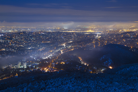 Ködös, párás téli kilátás a fővárosra kék órában, János-hegyről