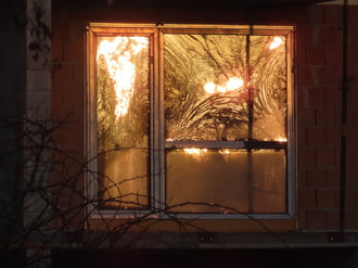 Napkelte fényei épülő ház ablakán