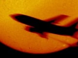 Hidrogén alfa keskenysávú szűrővel fényképezett nakorong elött átrepülő utasszállító repülőgép