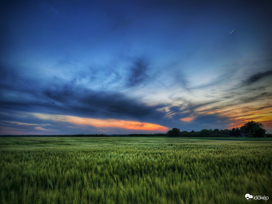 Szántó fölé nyújtózkodó alkonyati árnyak