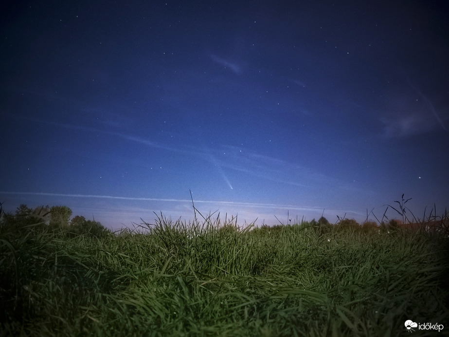 Holdfényben fürdő rét az év üstökösével
