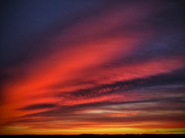 Felhők vonulatai a szilveszteri napnyugta idején