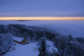 Téli mesevilág naplementekor két felhőzet között Kékestetőn.